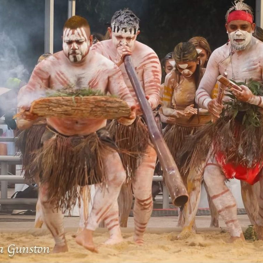 Dance group performing together on sand